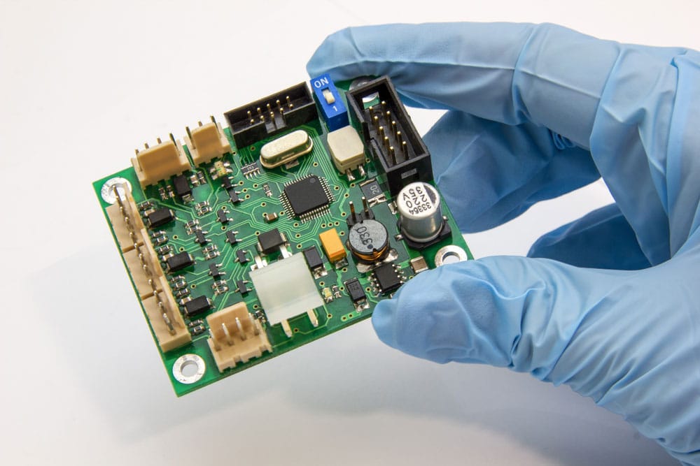 Holding pcb chip assembly on pcb background on the production of PCBs